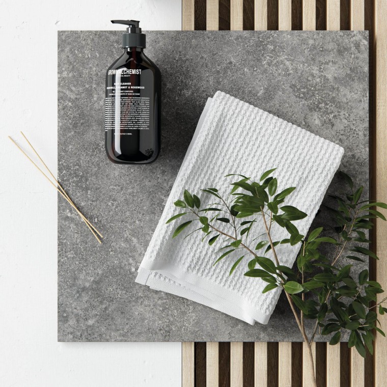 Ett grått badrum med inslag av trä